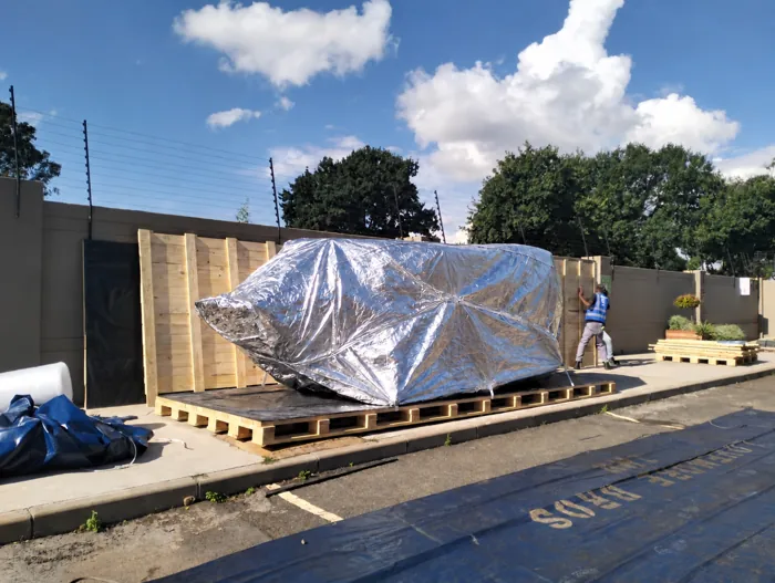 Foil-wrapped cargo secured on a timber skid